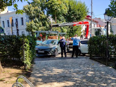 Romanya 'nın Bükreş kentinde 2022' de yasadışı park halindeki bir arabayı çekiciyle çekiyorlar.