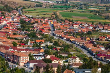 Rupea, Romanya 'daki tepeler, binalar, sokaklar, bitki örtüsü ve çevresiyle şehir merkezinin havadan görünüşü, 2021