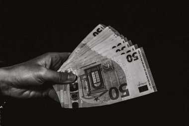 Avro paralarını saymak ve göstermek ya da para vermek. Dünya para kavramı, 50 EURO banknotları siyah üzerine izole edilmiş fotokopi alanı. Zengin insanlar kavramı, para biriktirmek ya da harcamak