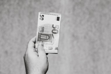 Avro parasını gösteren ve bahşiş, maaş gibi para veren ya da alan el ele tutuşmalar. 50 Avro banknotları izole edilmiş. Zengin iş adamları kavramı, para biriktirmek ya da harcamak.