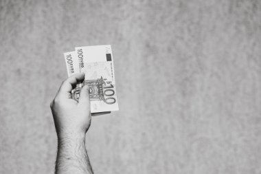 El ele tutuşup para göstermek ya da para vermek. Dünya para kavramı, 100 EURO banknotları izole edilmiş para birimi. Zengin iş adamları kavramı, para biriktirmek ya da harcamak.