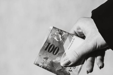 Dünya para kavramı, 100 İsviçre frangına yakın banknot, Chf 'in izole edilmiş fotoğrafı. El ele tutuşmak ya da İsviçre frangı vermek..