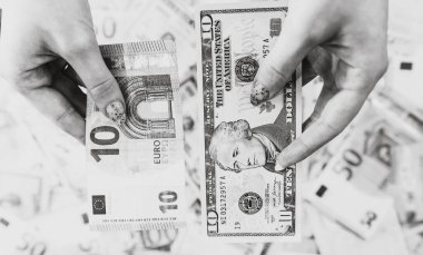 El ele tutuşan para, banknotların arkasında izole edilmiş. Euro ve Usd banknotları yakından karşılaştırıldı. Enflasyon, finans ve iş konsepti