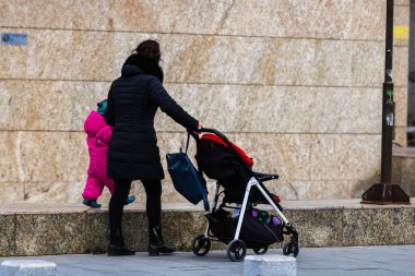 2022 Bükreş, Romanya 'da çocuklu bekar bir anne bebek arabasıyla geziyor.