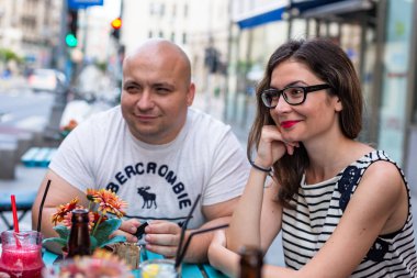 2022 Bükreş, Romanya 'da restoran masasında genç bir çift sosyalleşiyor