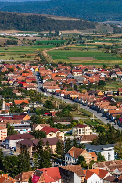 Rupea, Romanya 'daki tepeler, binalar, sokaklar, bitki örtüsü ve çevresiyle şehir merkezinin havadan görünüşü, 2021