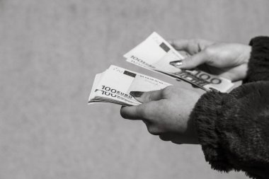 El ele tutuşup para göstermek ya da para vermek. Dünya para kavramı, 100 EURO banknotları izole edilmiş para birimi. Zengin iş adamları kavramı, para biriktirmek ya da harcamak.