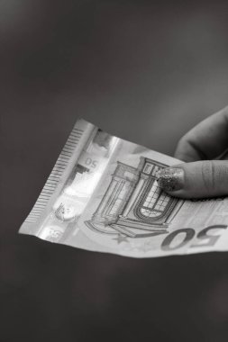 Kız elleri para veriyor. Bulanık bir arkaplanda EURO banknotları tutuluyor