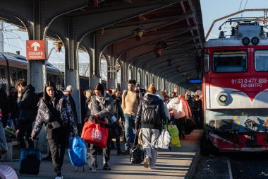 Bükreş, Romanya 'daki Bükreş Kuzey Tren İstasyonu' nda (Gara de Nord) trene binen ve inen insanlar, 2023