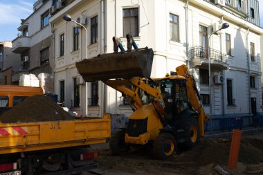 Construction workers at construction site and heavy duty bulldozer in Bucharest, Romania, 2023