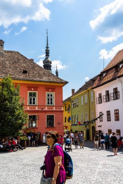 İnsanlar ve turistler Sighisoara, Romanya 'nın eski kalesinde 2022' de dolaşıyorlar.