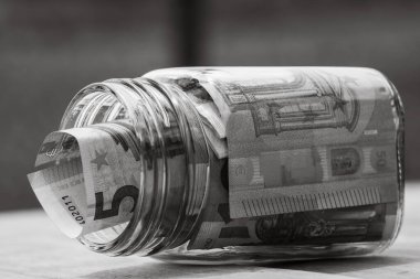 Cam bir kavanozda para biriktirme kompozisyonu. Yatırım yapma ve para tutma kavramı, tecrit edilmiş..