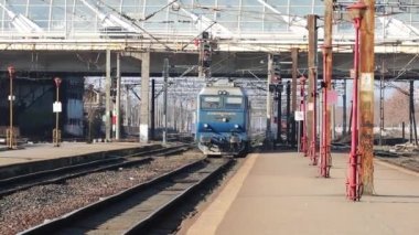 Train in motion at train platform at North Rail station (Gara de Nord). Train transport infrastructure. Bucharest, Romania, 2023