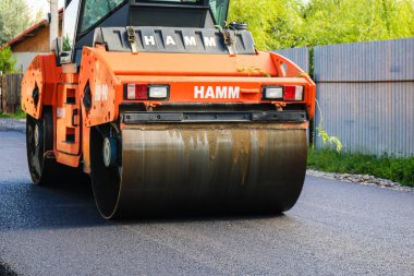 İşçiler ve asfaltlama makineleri. Romanya 'nın Bükreş kentinde inşaat ve yeni karayolunun asfaltlanması, 2022