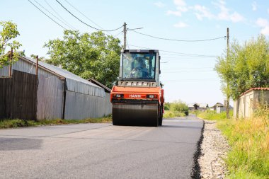 İşçiler ve asfaltlama makineleri. Romanya 'nın Bükreş kentinde inşaat ve yeni karayolunun asfaltlanması, 2022