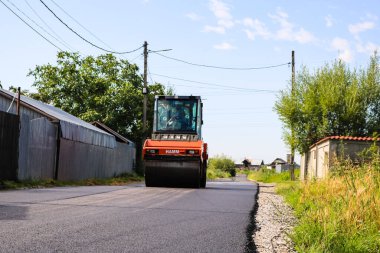 İşçiler ve asfaltlama makineleri. Romanya 'nın Bükreş kentinde inşaat ve yeni karayolunun asfaltlanması, 2022