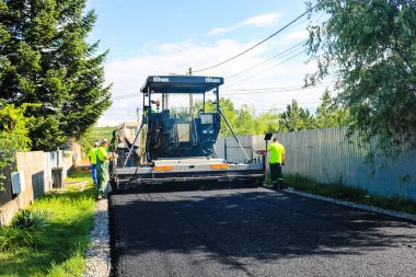 İşçiler ve asfaltlama makineleri. Romanya 'nın Bükreş kentinde inşaat ve yeni karayolunun asfaltlanması, 2022
