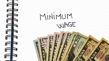 Minimum wage handwriting  text on paper, on office agenda. Copy space. clipart