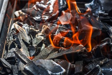 Işıl ışıl yanan ızgara ocağı. Kırmızı alevler, kömür kömürleri ve közlerle birlikte.