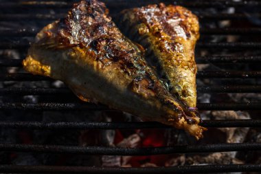 Kömür ızgarasında ızgara uskumru ve duman..