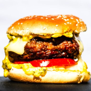 Lezzetli ev yapımı çizburger. Turşulu çizburger, domates, soğan, erimiş peynir.