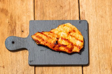 Izgara bifteği, izole edilmiş küçük siyah kesme tahtasına yakın tut. Barbekü, ızgara ve yemek konsepti.