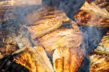 Kömür ızgarasında ızgara uskumru ve duman..