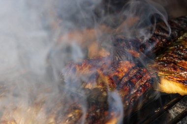 Kömür ızgarasında ızgara uskumru ve duman..