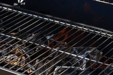 Işıl ışıl yanan ızgara ocağı. Kırmızı alevler, kömür kömürleri ve közlerle birlikte.