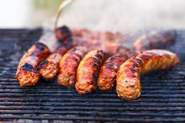 Kömür mangalında ızgara sosis. Lezzetli barbekü, yemek konsepti, ızgaradaki yemek ve ızgaradaki sosislerin ayrıntıları.