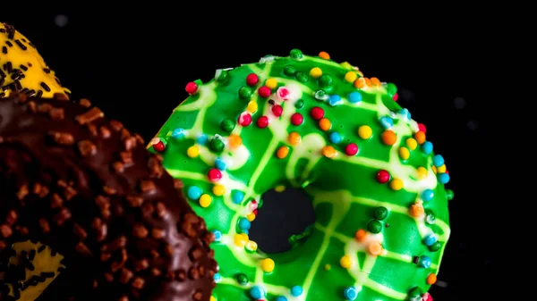 Frisch Leckere Farbige Donuts Mit Streusel Auf Schwarzem Hintergrund — Stockfoto