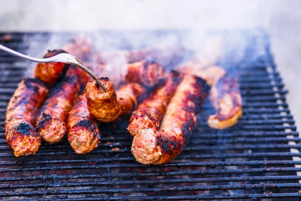Kömür mangalında ızgara sosis. Lezzetli barbekü, yemek konsepti, ızgaradaki yemek ve ızgaradaki sosislerin ayrıntıları.