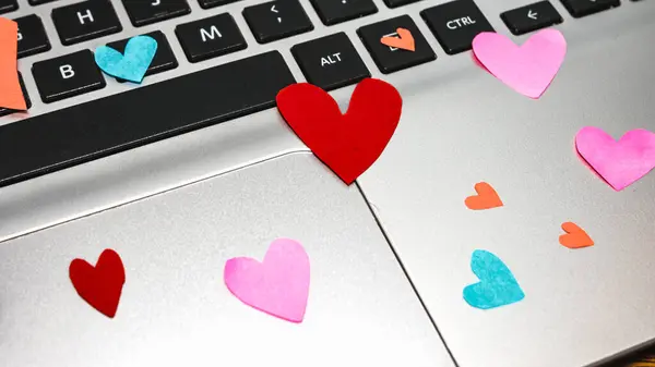 Heart shaped paper cut out on keyboard, love message and Valentine`s day concept.
