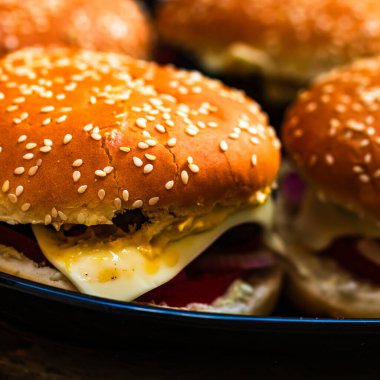 Lezzetli ev yapımı çizburger. Turşulu çizburger, domates, soğan, erimiş peynir.