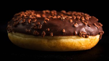 Çikolata kaplı çörek ve çikolata parçacıkları izole edilmiş. Lezzetli çörekleri yakın çekin..