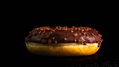 Çikolata kaplı çörek ve çikolata parçacıkları izole edilmiş. Lezzetli çörekleri yakın çekin..