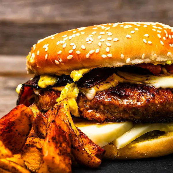 stock image Tasty home made cheeseburger. Cheese burger with pickles, tomatoes, onion, melting cheese