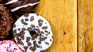 Masada fotokopi alanı olan renkli çörekler. İzole edilmiş donutların üst görünümü.