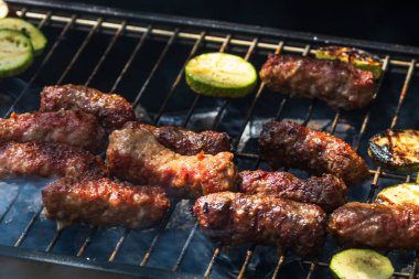 Mangalda mangalda sebzeli mici ya da mititei adında ızgara köfte. Ateşli mangal kömürü.