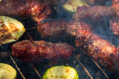 Mangalda mangalda sebzeli mici ya da mititei adında ızgara köfte. Ateşli mangal kömürü.