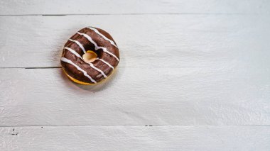 Beyaz ahşap masada renkli çörekler. Şekerli, şekerli, şekerli, şekerli, şekerli. Kopyalama alanı olan üst görünüm