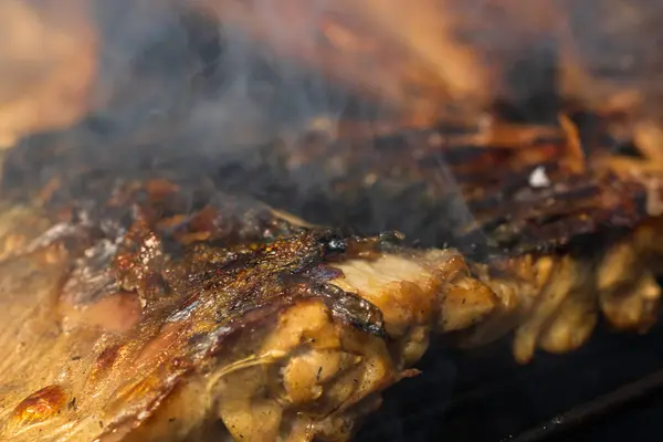 Kömür ızgarasında ızgara uskumru ve duman..