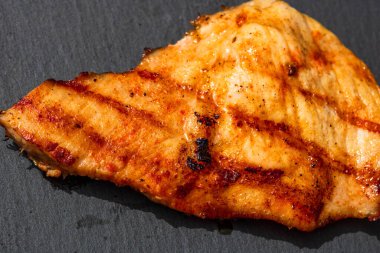 Izgara bifteği, izole edilmiş küçük siyah kesme tahtasına yakın tut. Barbekü, ızgara ve yemek konsepti.