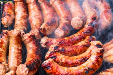 Barbekü ızgarasında ev yapımı sosislerin detaylarını kapat. Barbekü, ızgara ve yemek konsepti.
