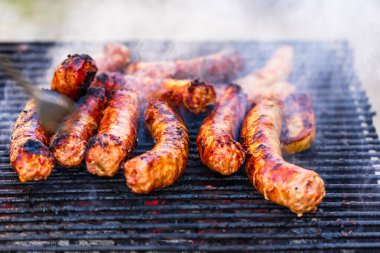 Kömür mangalında ızgara sosis. Lezzetli barbekü, yemek konsepti, ızgaradaki yemek ve ızgaradaki sosislerin ayrıntıları.