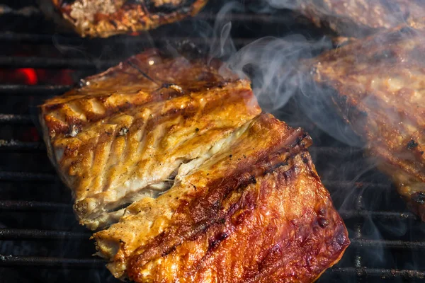 Kömür ızgarasında ızgara uskumru ve duman..