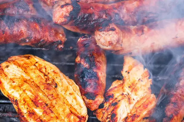 Ev yapımı tavuk, domuz bifteği ve ızgarada sosis detaylarını kapat. Barbekü, ızgara ve yemek konsepti.