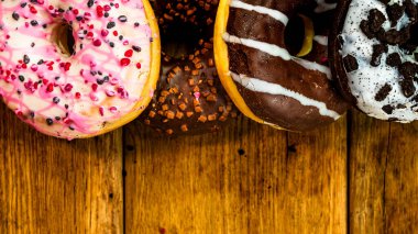 Masada fotokopi alanı olan renkli çörekler. İzole edilmiş donutların üst görünümü.