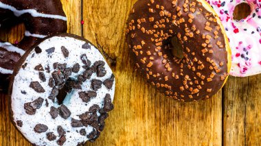 Masada fotokopi alanı olan renkli çörekler. İzole edilmiş donutların üst görünümü.