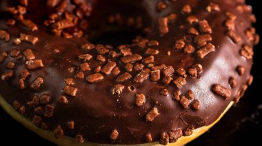Çikolata kaplı çörek ve çikolata parçacıkları izole edilmiş. Lezzetli çörekleri yakın çekin..